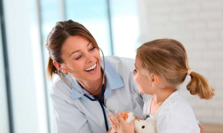 Woman doctor and girl smiling